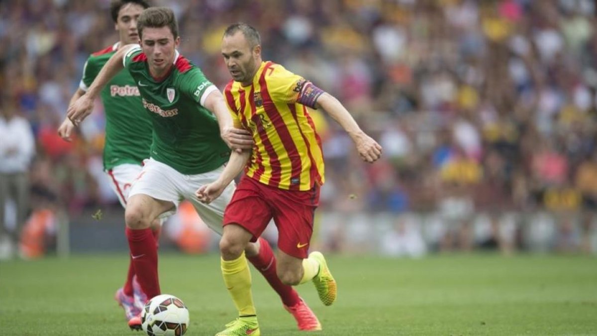 Laporte trata de frenar a Iniesta en un partido de Liga.-