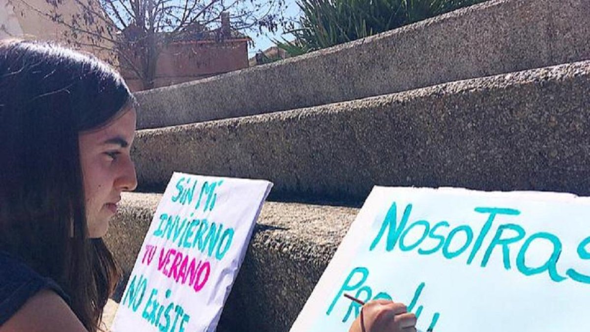 Una joven prepara pancartas en las que reivindica que el papel que juegan los pueblos.-E.M.