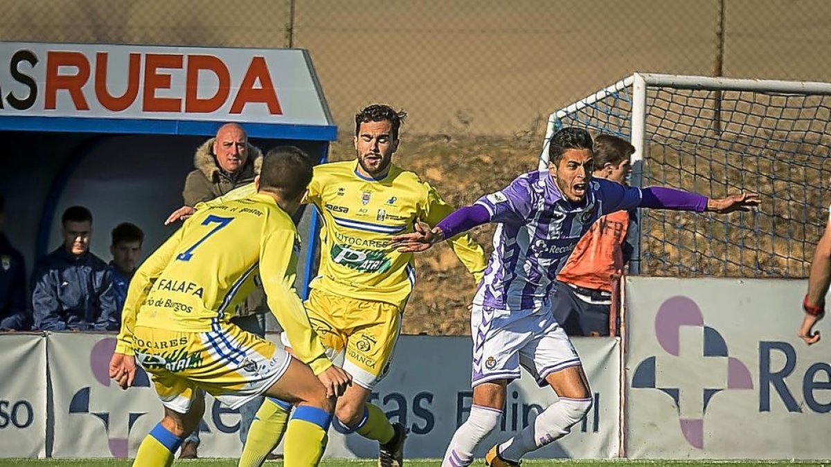 Anuar saca el balón ante dos jugadores de la Arandina.-MIGUEL ÁNGEL SANTOS