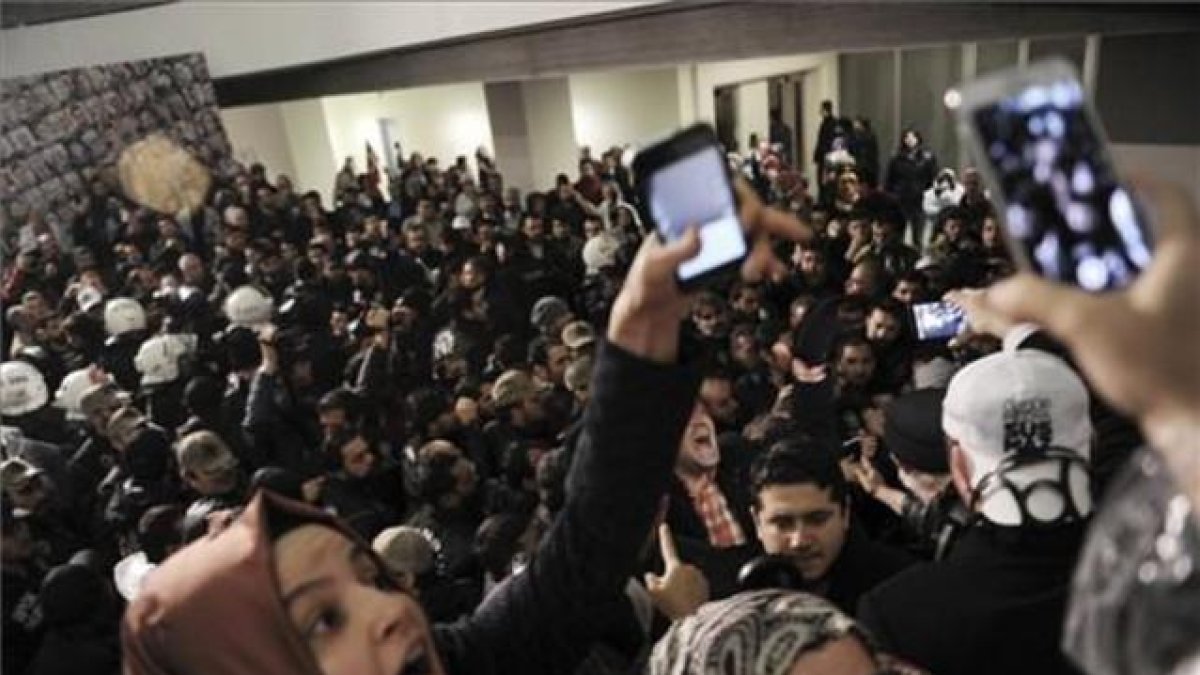 Un grupo de periodistas reaccionan ante el asalto de los antidisturbios en al sede del diario 'Zanan', es Estambul.-AFP