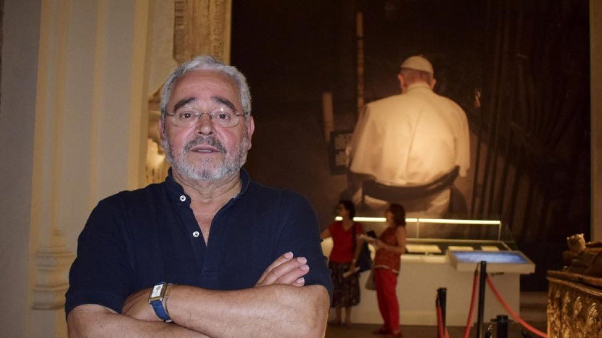 Alberto Cándido López, hijo del mesonero Cándido, con los cochinillos asados que han dado la vuelta al mundo, sobre las andas, y un retrato de su padre detrás, en el Mesón de Cándido de Segovia.-ARGICOMUNICACIÓN