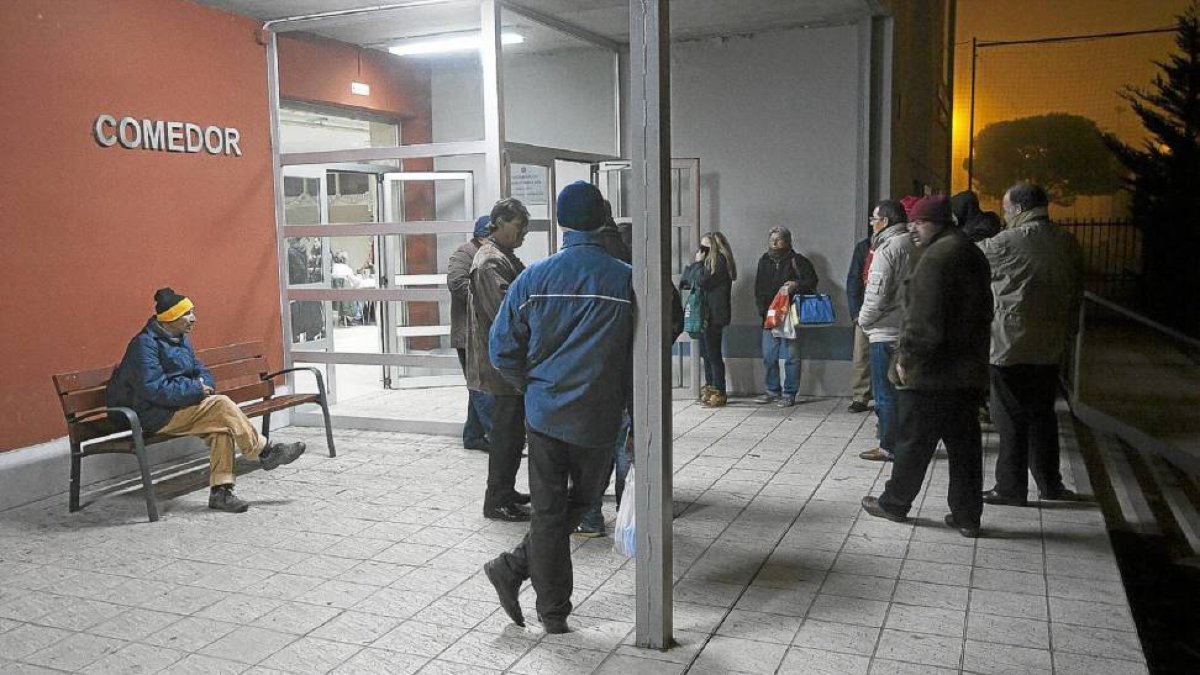 Un grupo de personas espera para acceder al comedor social-Pablo Requejo