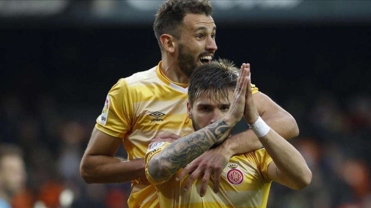 Stuani abraza a Portu, que pide perdón por marcar al Valencia.-/ MIGUEL LORENZO