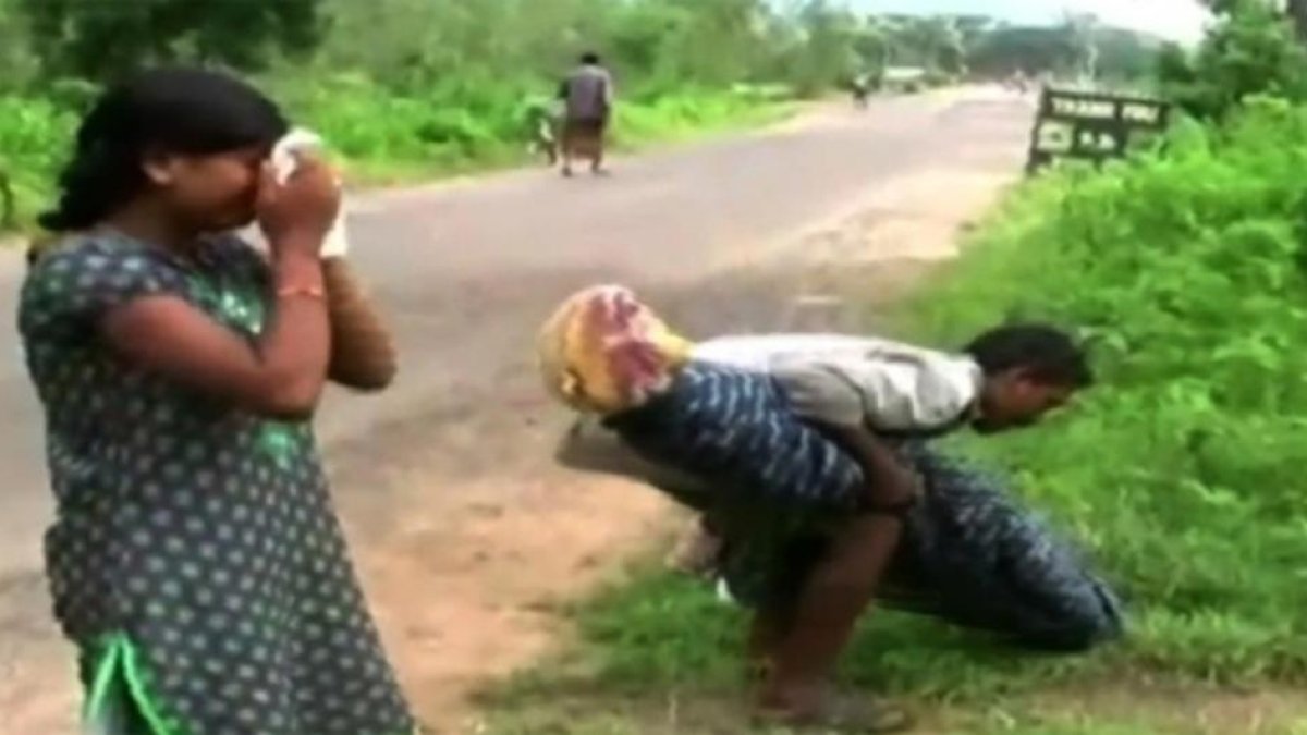 La hija de Manjhi llora mientras su padre carga con el cuerpo de su mujer.-