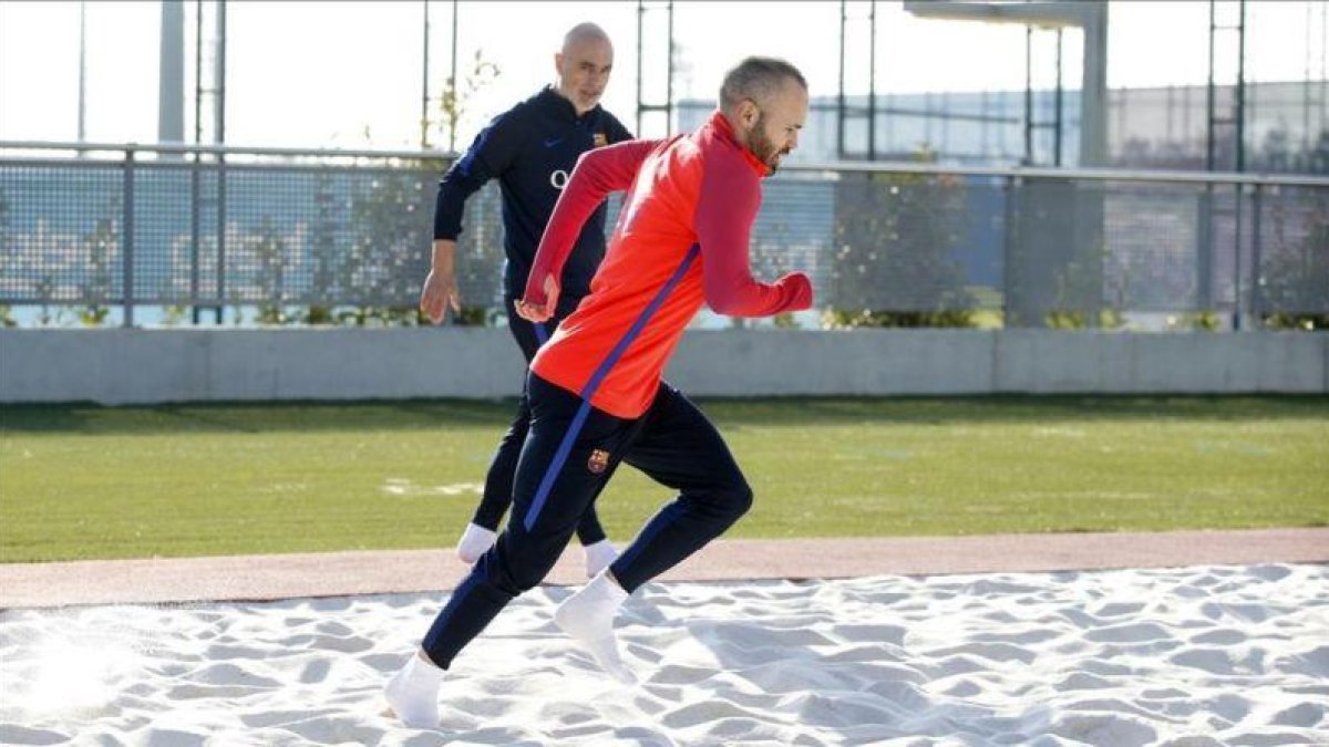 Iniesta, en una sesión de recuperación en la ciudad deportiva del Barça junto a Juanjo Brau, fisioterapeuta del club.-FC BARCELONA