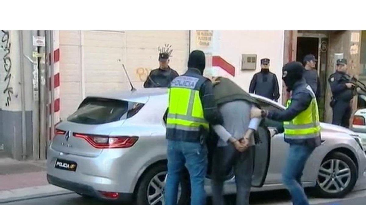 El detenido en Valladolid, Alí, de 31 años, es introducido en el cohe tras el registro en San José de Calasanz.-TVE