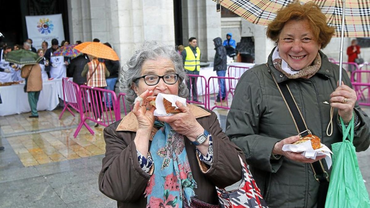 Dos mujeres con su porción de  la corona de San Pedro Regalado en la degustación celebrada ayer en la Plaza Mayor.-J. M. LOSTAU