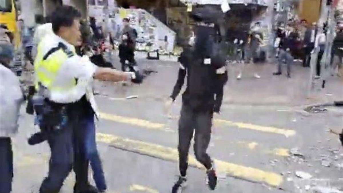 Un policía en Hong Kong dispara contra los manifestantes.-AP