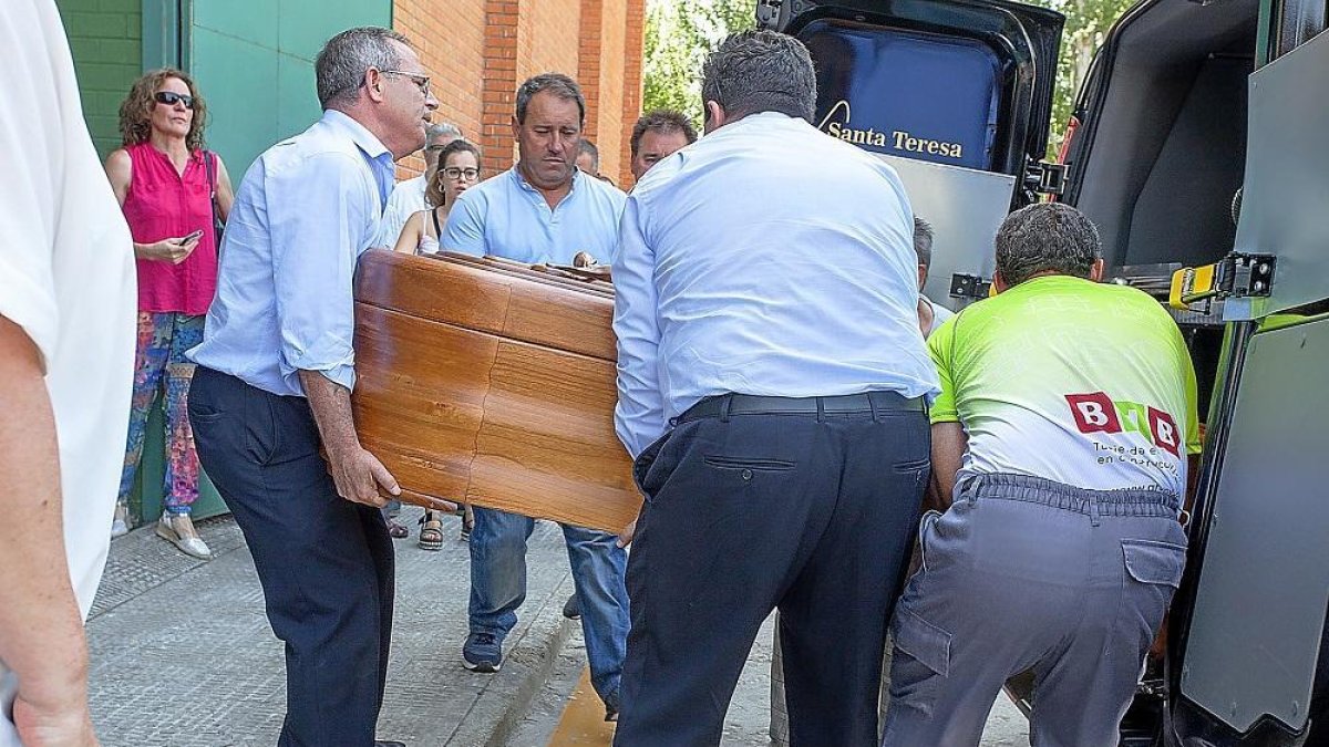 Varios hombres introducen el féretro de una de las víctimas del brutal accidente de Galisancho.-ICAL