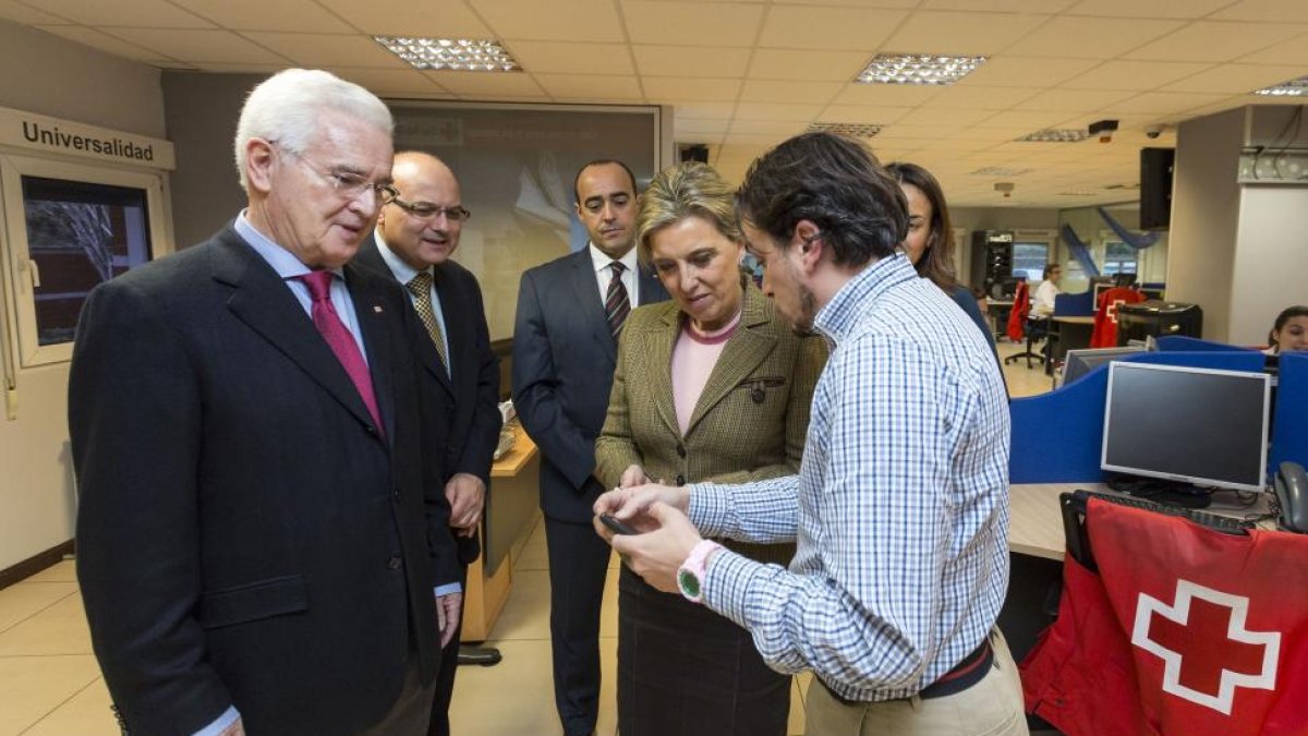 La delegada del Gobierno en Castilla y León, María José Salgueiro, atiende junto al presidente regional de Cruz Roja, José Varela, las explicaciones de los técnicos de Cruz Roja durante su visita para conocer el servicio telefónico de Atención y Protecció-Ical