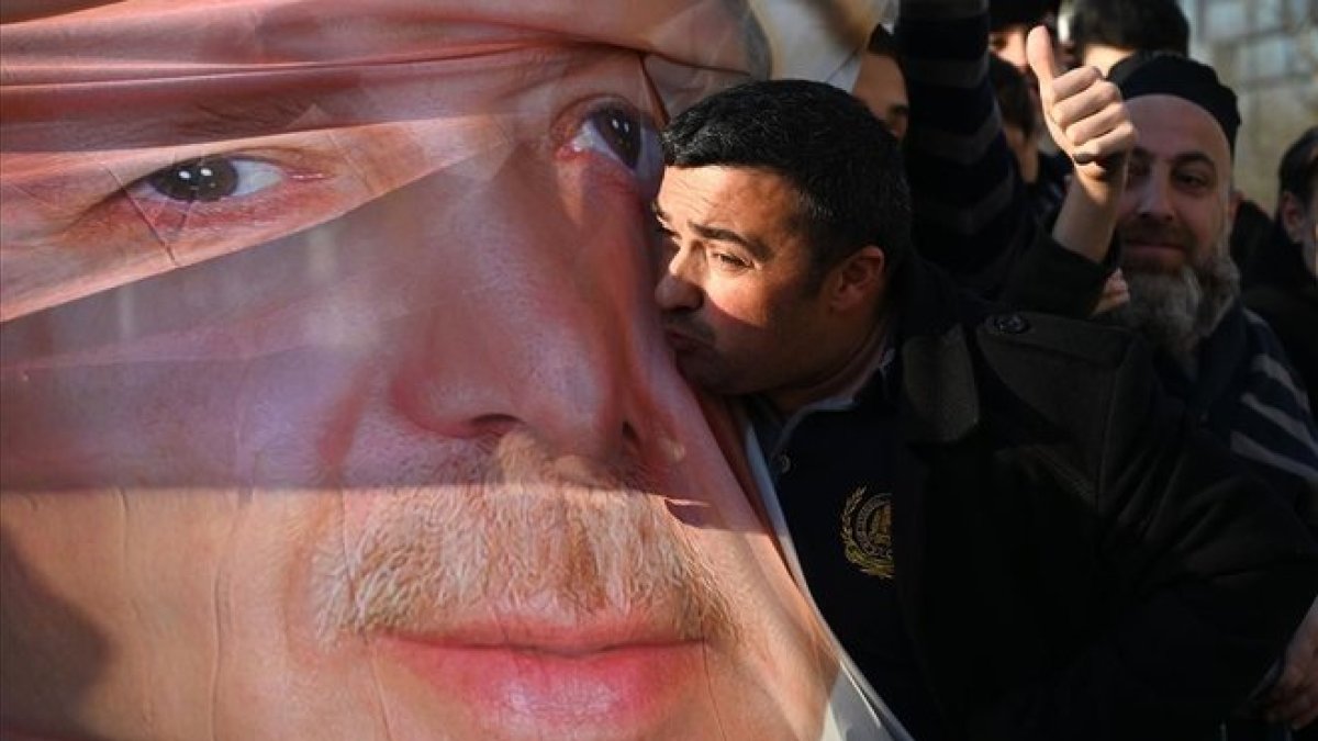Un simpatizante de Erdogan besa una foto con la imagen del mandatario turco, en Estambul.-OZAN KOSE (AFP)