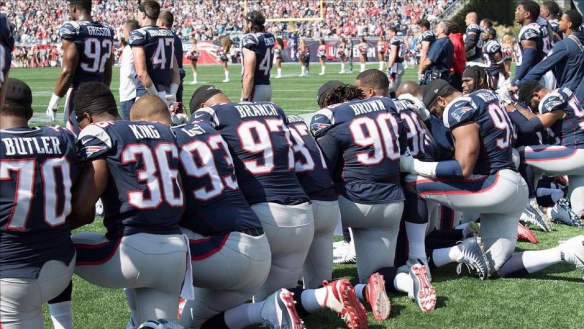 Los jugadores de New England Patriots protestan arrodillados durante el himno-JOHN CETRINO
