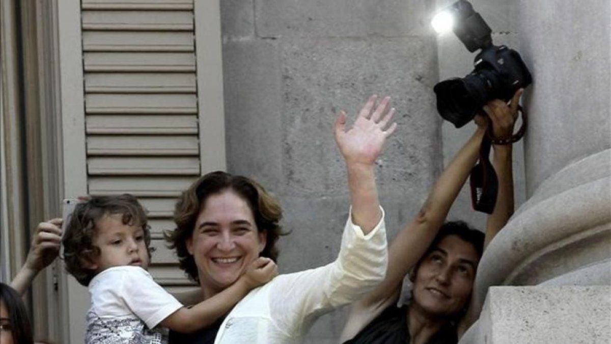 Ada Colau, con su hijo Luca, en el balcón del ayuntamiento contemplando el año pasado a los 'castellers' de la ciudad que celebraron el 46 aniversario de su creación en la plaza de Sant Jaume.-EFE / ALBERTO ESTEVEZ