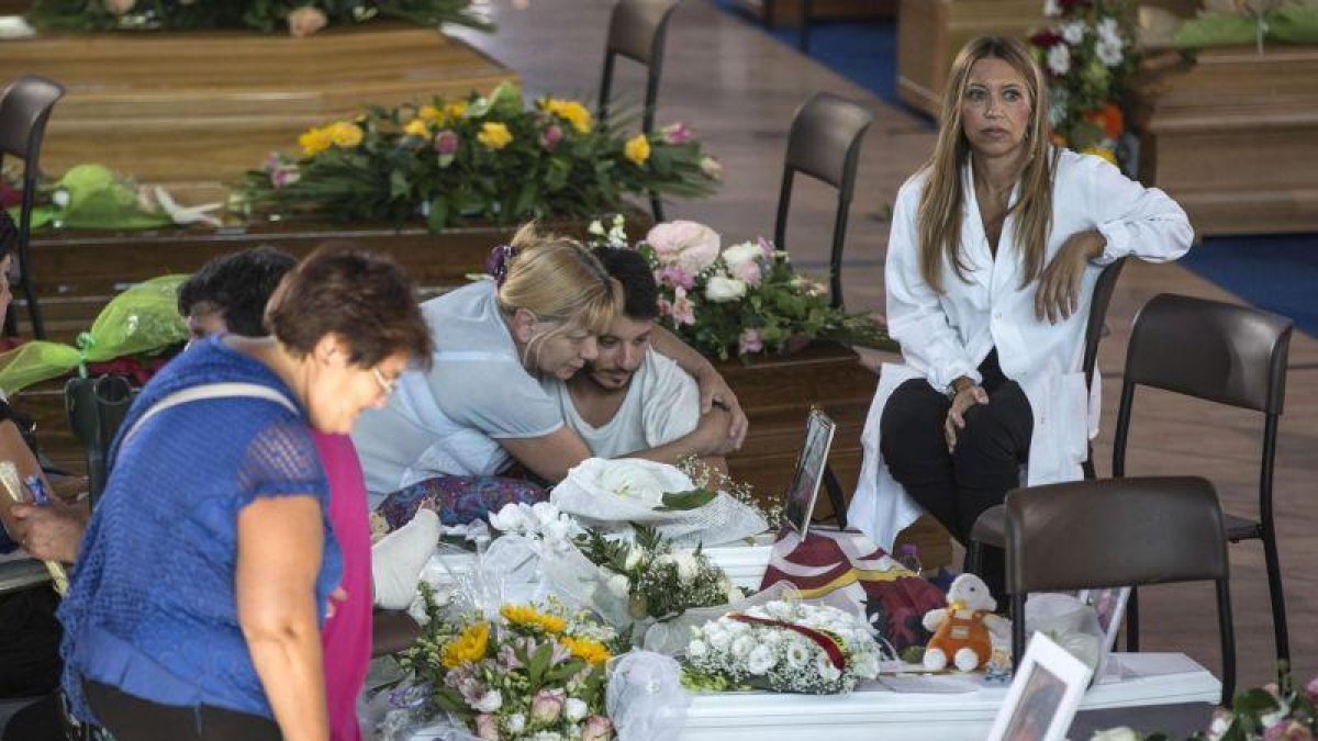 Familiares y amigos, junto a los féretros de los fallecidos en el terremoto de Italia del miércoles, este sábado, en Ascoli Piceno.-EFE / MASSIMO PERCOSSI