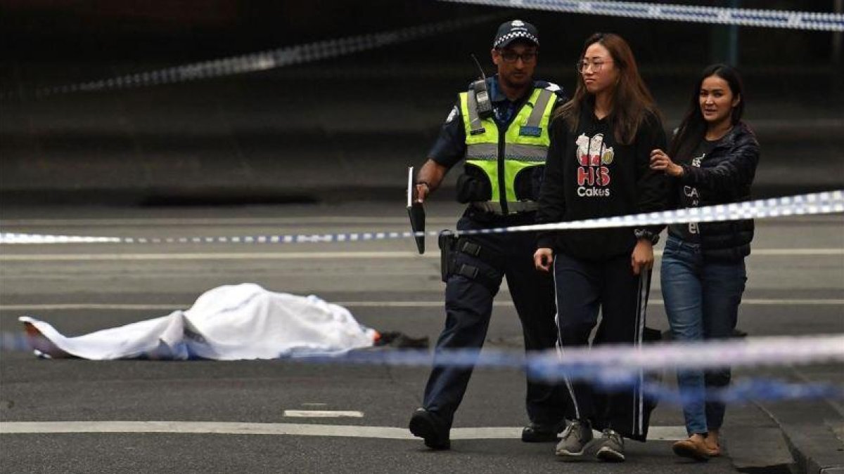 La policía despeja la zona junto al cadáver de la víctima del apuñalamiento en Melbourne.-EL PERIÓDICO