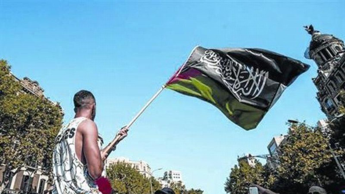 Un joven exhibe una bandera de Al Qaeda en una manifestación en Barcelona, en julio.-FACEBOOK
