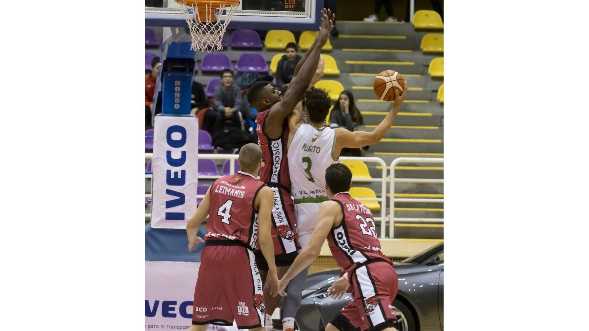 Aboubacar ejerce de muro impenetrable ante el jugador del Tau Castelló cedido por Valencia Basket, Puerto.-PABLO REQUEJO / PHOTOGENIC