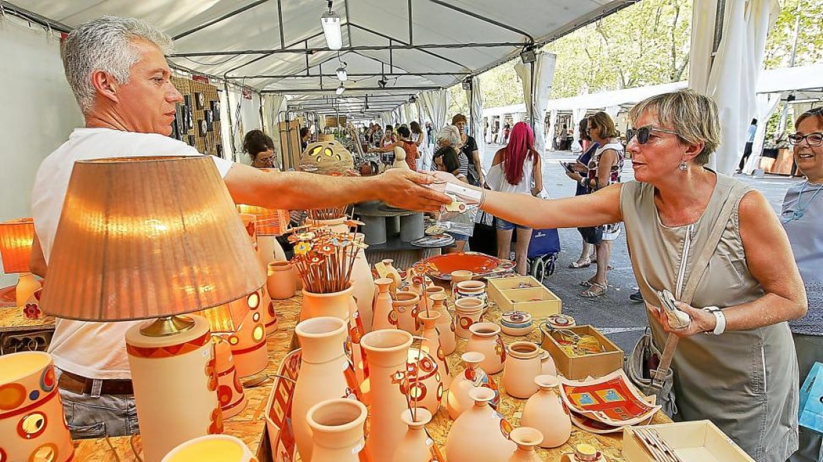 Una mujer compra un recuerdo en la Feria de Cerámica y Alfarería.-J. M. LOSTAU