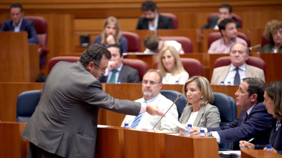 El procurador socialista José Ignacio Martín Benito entrega una carta al consejero de Sanidad, Antonio Sáez, en el Pleno de las Cortes de Castilla y León.-ICAL