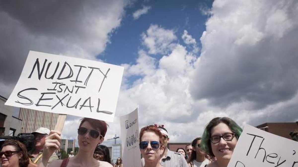 Manifestantes en la ciudad de Waterloo este domingo protestando por su derecho en Canadá de hacer toples.-Foto: AP / HANNAH YOON