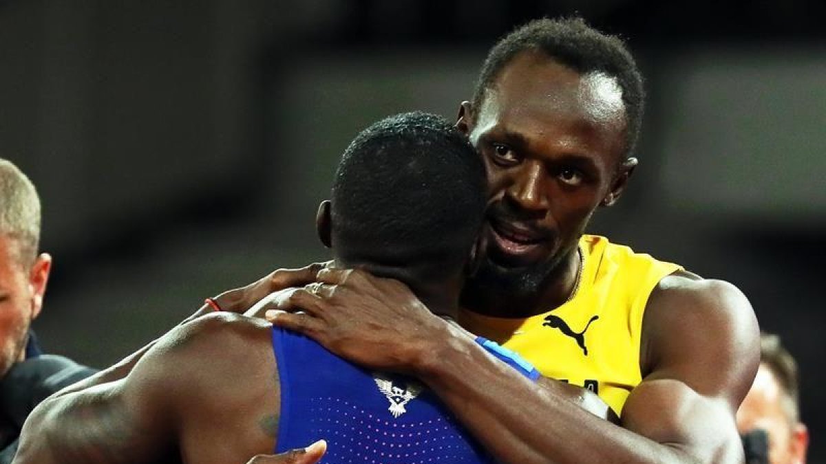 Bolt se abraza con Gatlin al final de la carrera.-EFE
