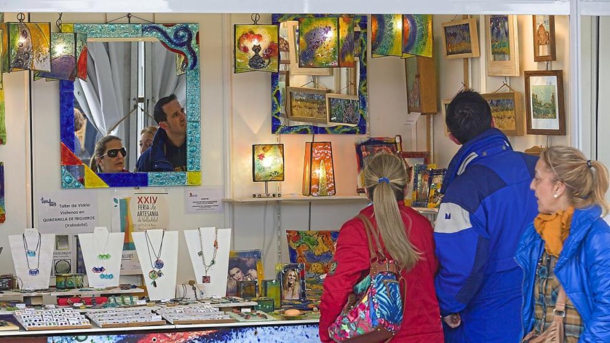 Una pareja observa los artículos de uno de los puestos en la Feria de Artesanía.-P. REQUEJO