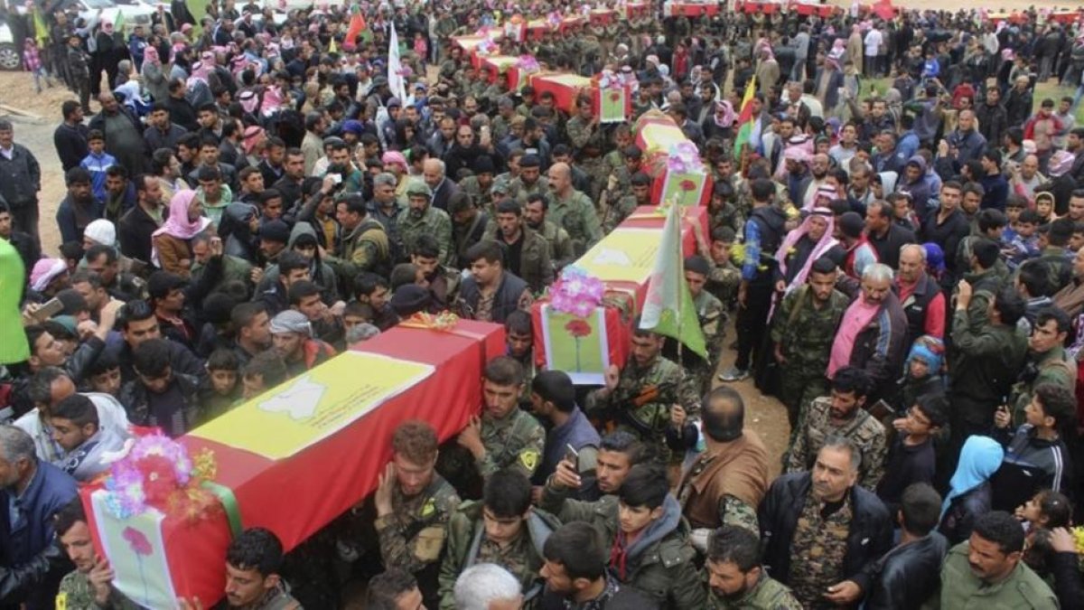 Miliciamos de las Fuerzas Democráticas de Siria llevan los féretros de sus compañeros muertos en el ataque perpetrado por error por aviones de EEUU.-AP