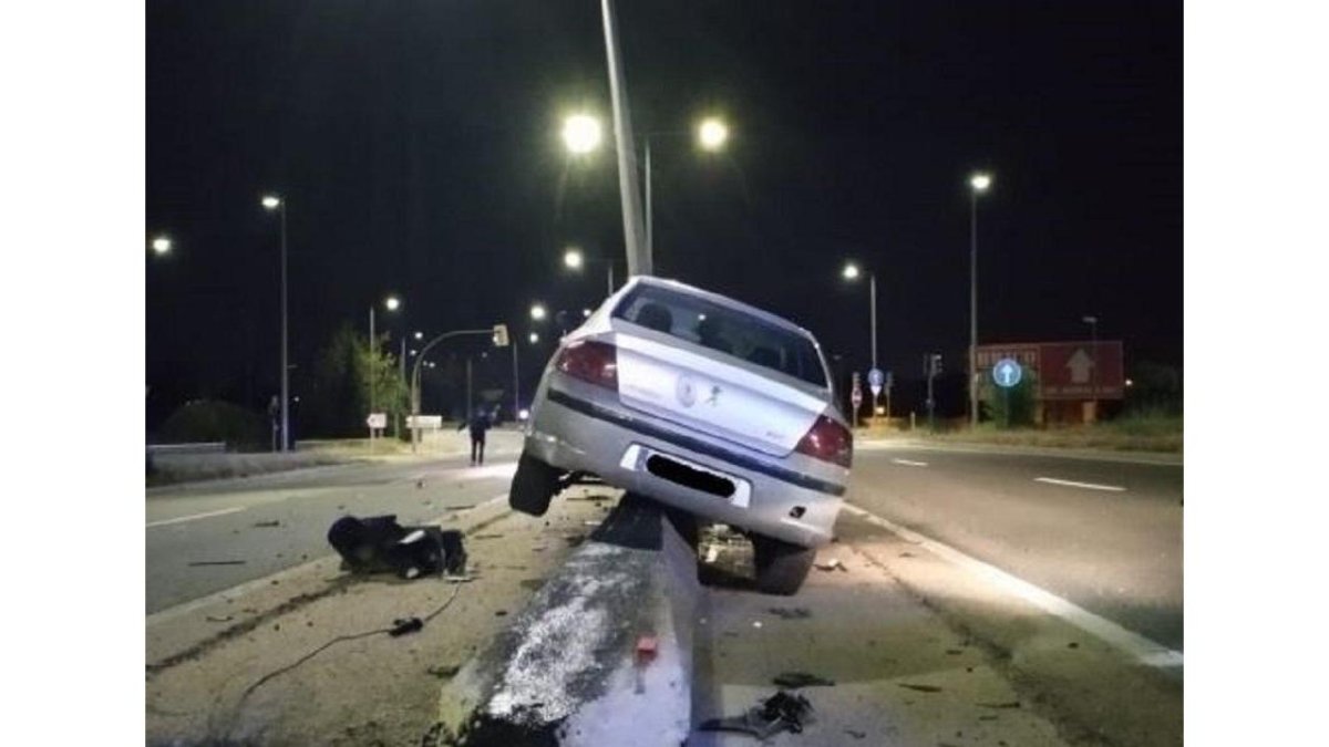 Vehículo en la mediana tras derribar un semáforo y doblar una farola después de que el conductor mirara el móvil.-E. M.