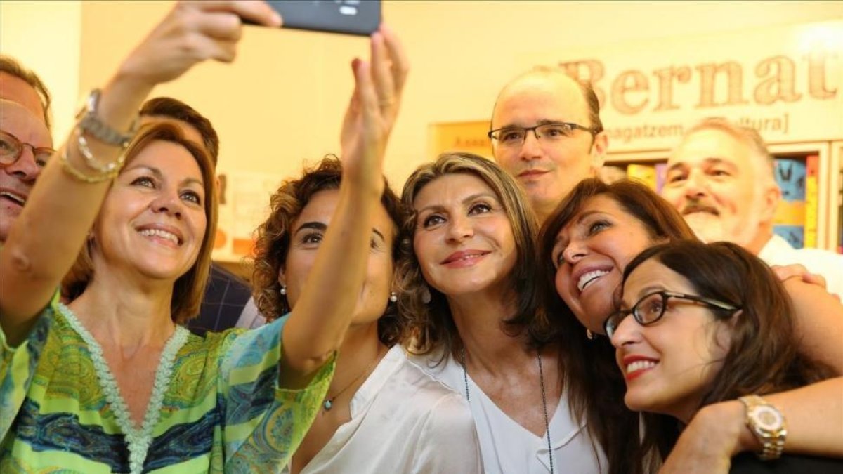 María Dolores de Cospedal, acompañada de la ex ministra Dolors Montserrat, fotografiándose con afiliados y simpatizantes en la sede del PP en Barcelona.-/ RICARD CUGAT