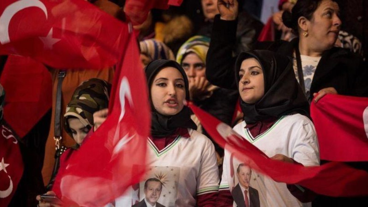 Dos mujeres con pañuelo y banderas turcas, en un mitin del partido gubernamental a favor del 'sí' en el próximo referéndum constitucional, en Ankara, el 25 de febrero.-GETTY IMAGES / CHRIS MCGRATH