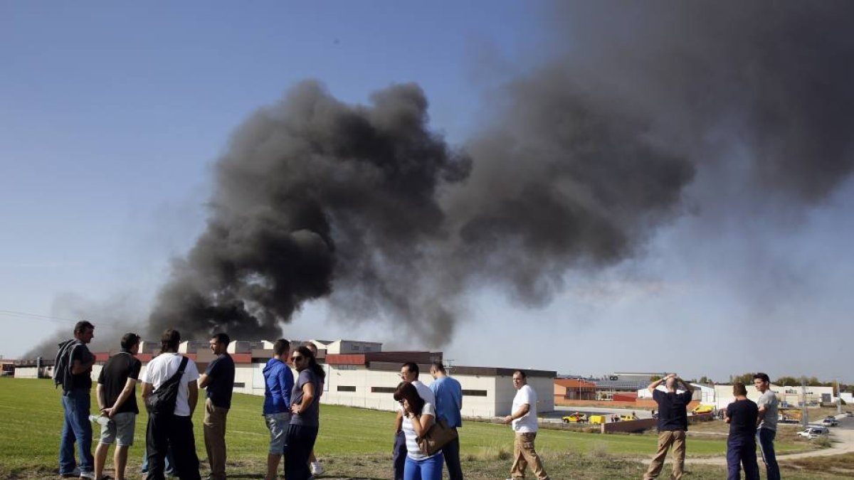 Incendio en la fábrica Composites Avanzados, en Arévalo. En la foto, trabajadores de la fábrica contemplan el incendio desde una colina cercana-Ical