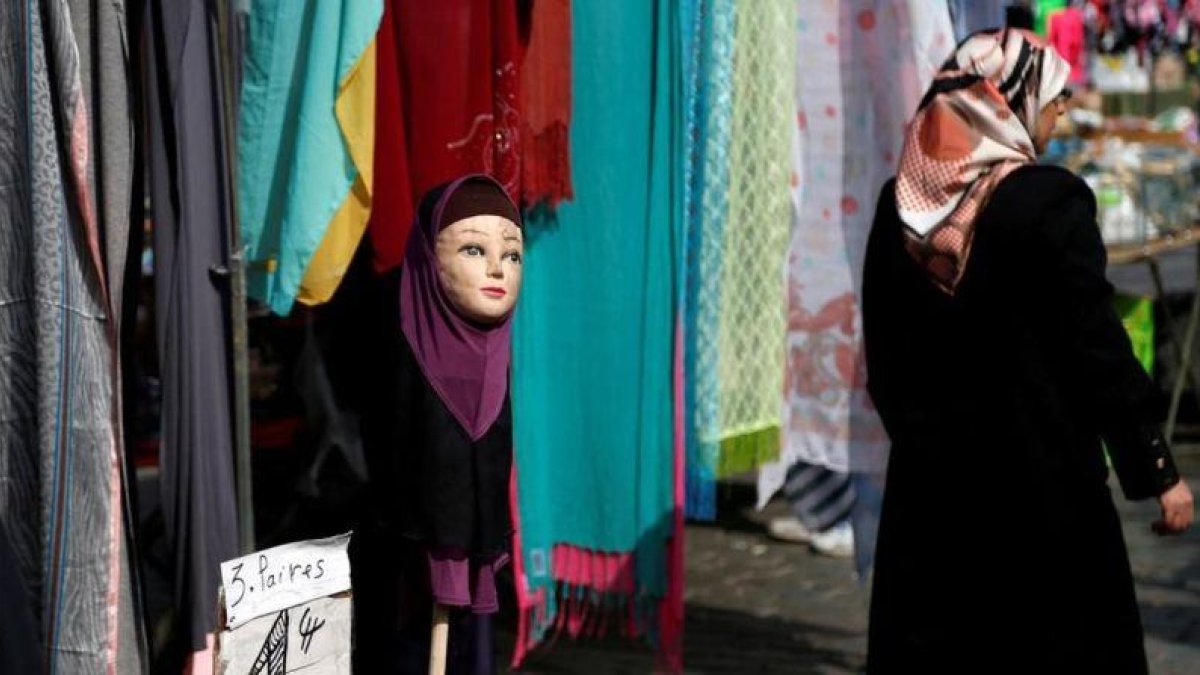 Una mujer musulmana pasa junto a una tienda de venta de pañuelos islámicos en Bruselas.-REUTERS / FRANCOIS LENOIR