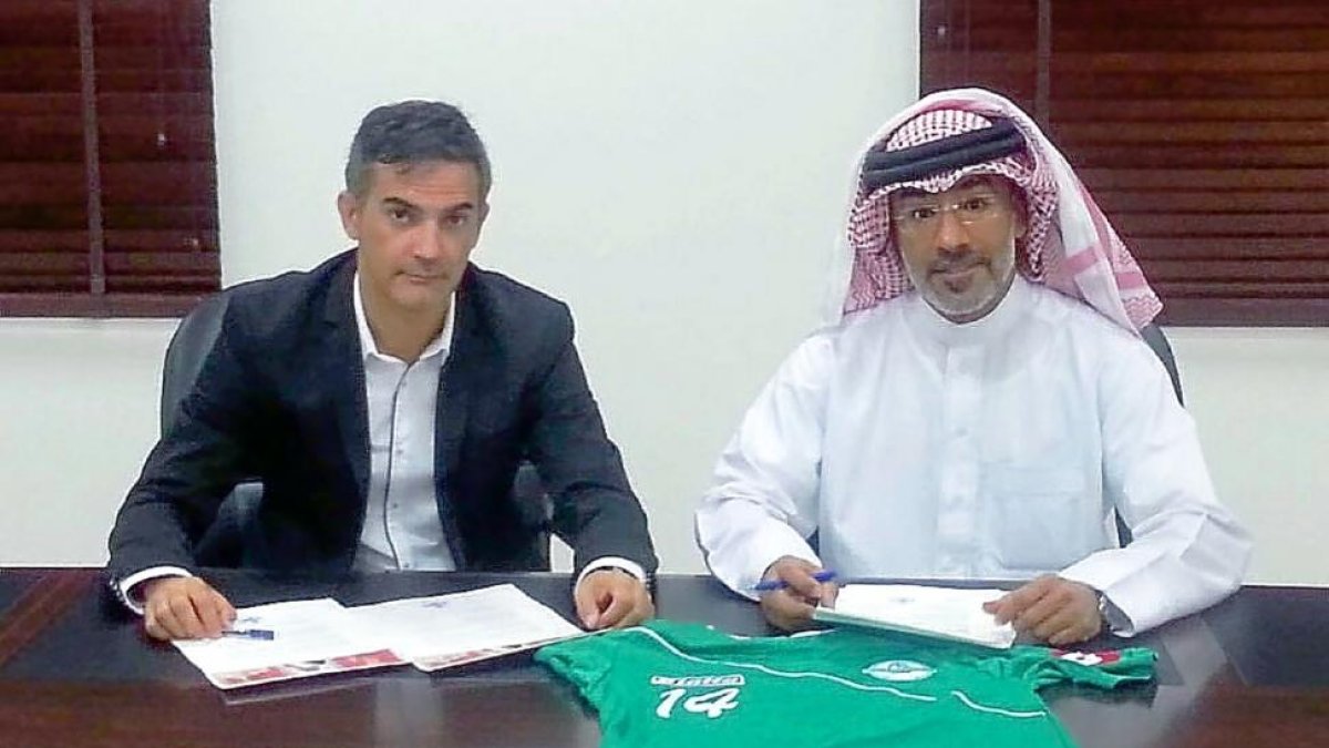 El vallisoletano Manuel Retamero firmando su contrato con el dueño del Budaiya Club de Bahréin.-EL MUNDO