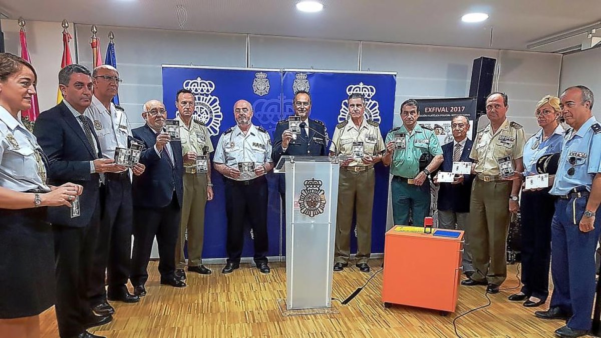 Los asistentes a la presentación mostrando la tarjeta conmemorativa del acto.-EL MUNDO