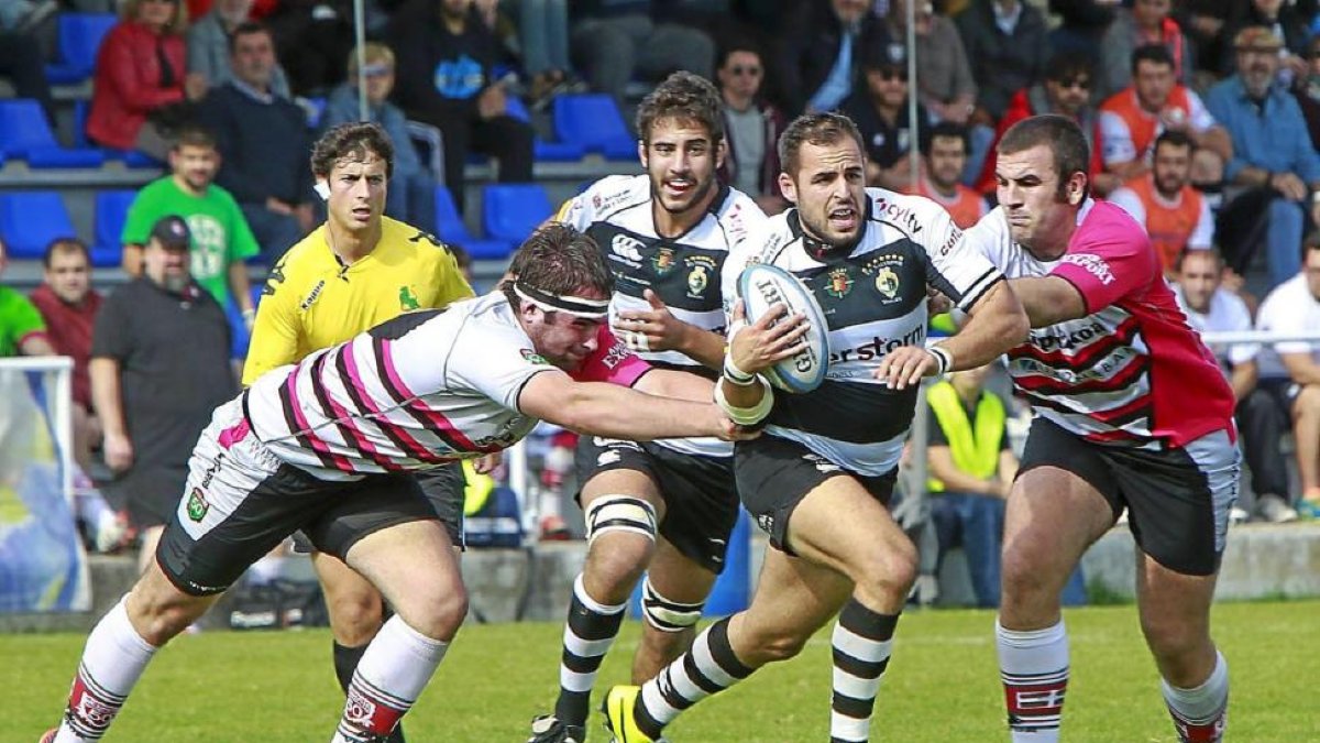 Sam Katz se escapa de dos jugadores del Hernani durante el partido de ayer.-J. M. Lostau