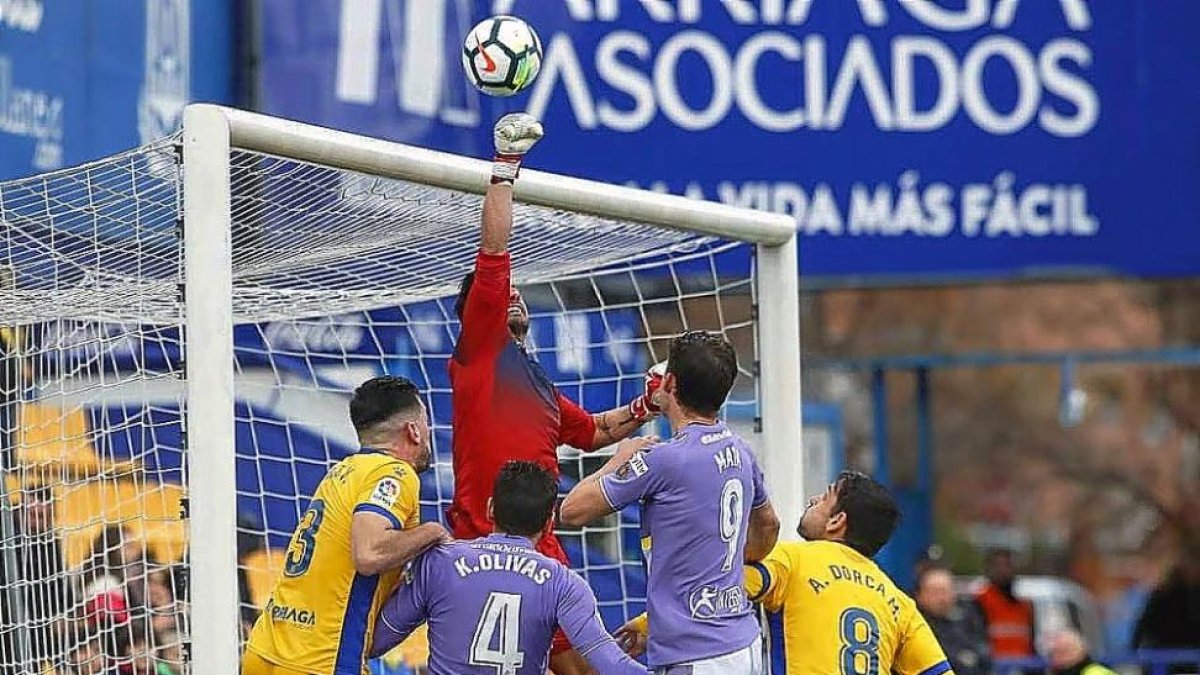 Casto despeja con el puño ante la presencia de Mata y Kiko Olivas, ayer en Alcorcón.-PHOTO-DEPORTE