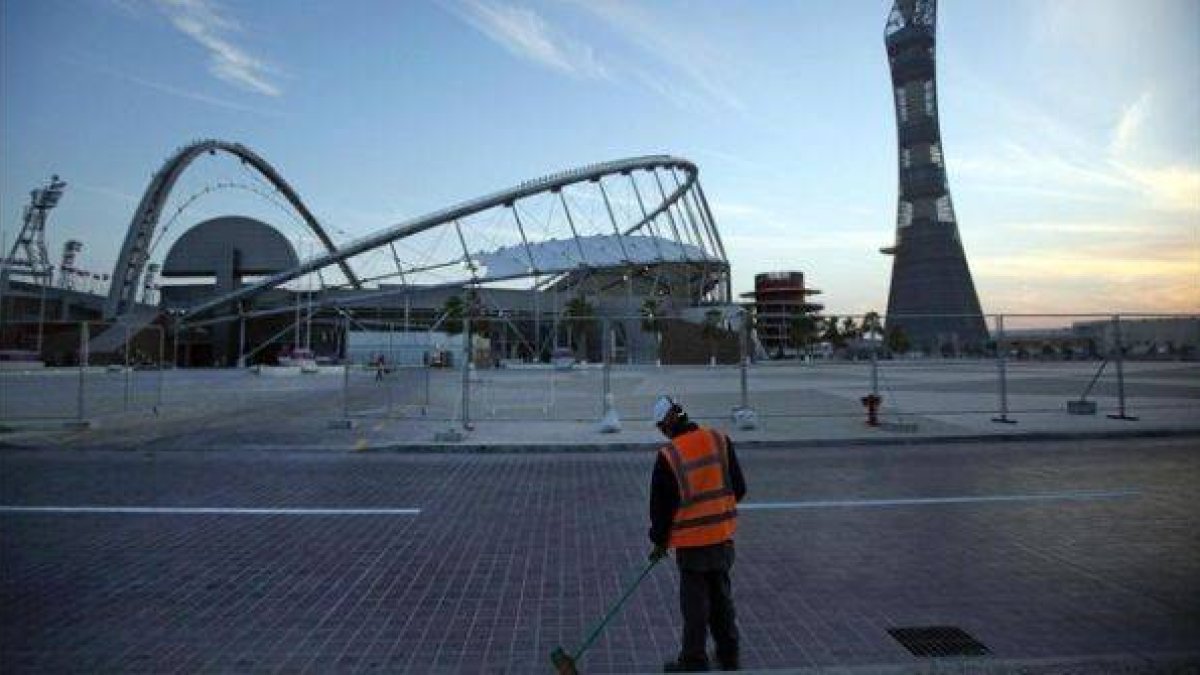 Un trabajador limpia uno de los accesos al complejo deportivo Khalifa, en Doha (Catar), en enero del 2011.-Foto: AP / KIN CHEUNG