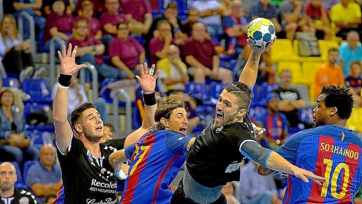 Roberto se dispone a lanzar tras salvar la defensa de Viran Morros y Sorhaindo en el partido del Palau.-PHOTO-DEPORTE