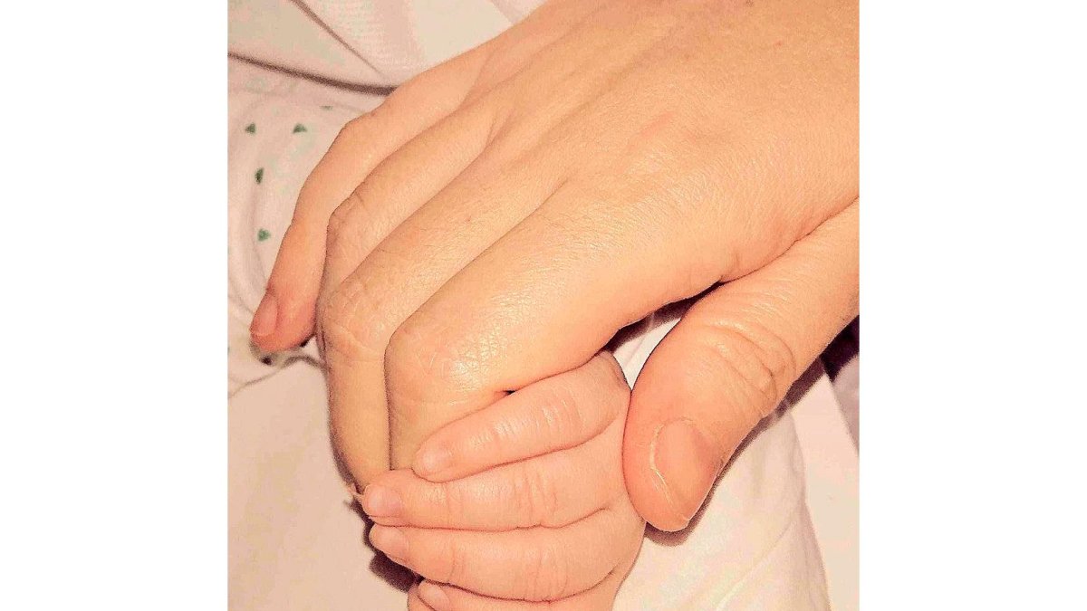 Foto facilitada por la madre en la que sujeta la pequeña mano de su hija. E.M.