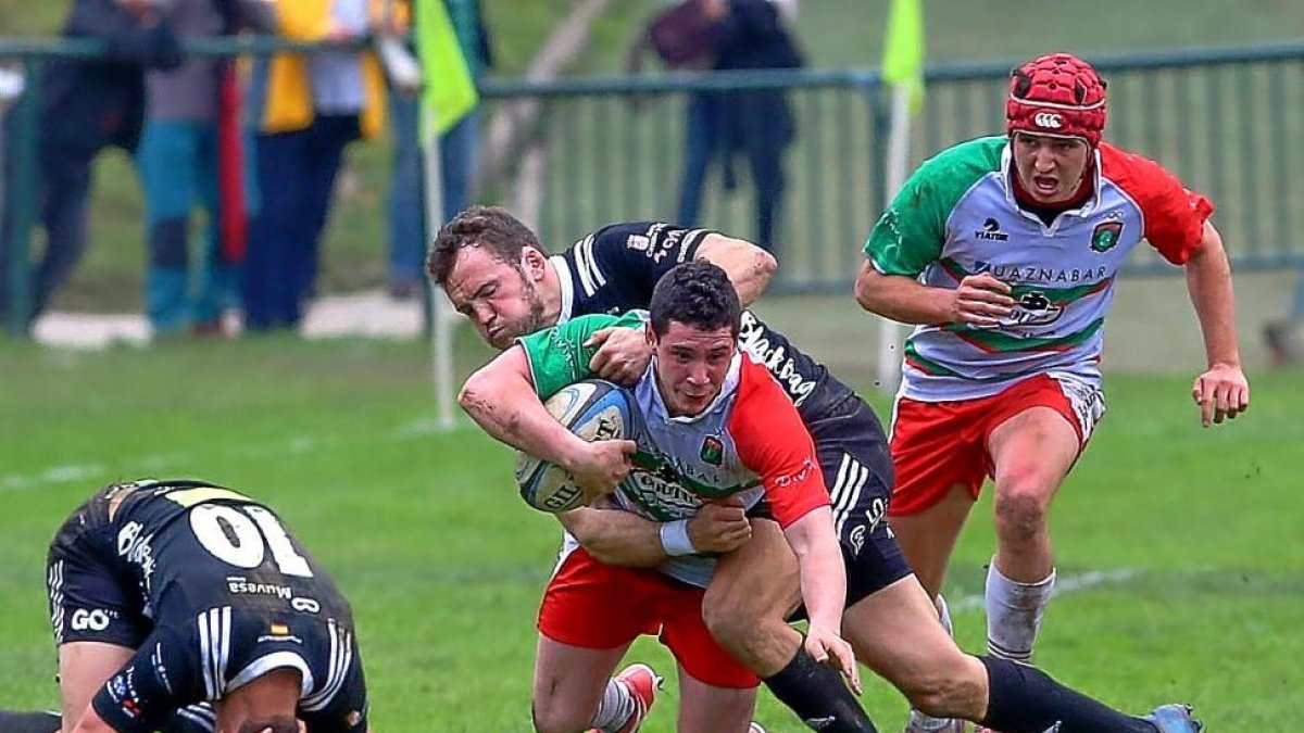 Carter placa a un jugador del Hernani, mientras Graaff se duele de un golpe en la cabeza.-JAVI COLMENERO