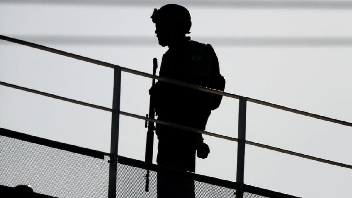 Un militar vigila desde un puente en una ciudad tomada por las fuerzas de seguridad.-EFE / JORGE ZAPATA