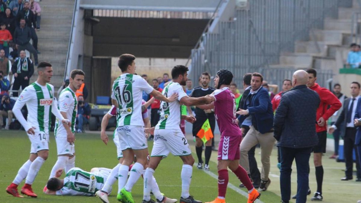 Tángana formada tras la entrada de Luismi, con casqueta, sobre Fernández, que yace tumbado en el césped, siendo sustituido.-PHOTO-DEPORTE