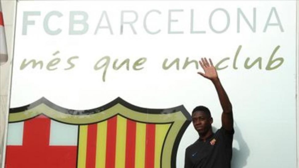 Dembélé saluda en la fachada de lasoficinas del Barça.-REUTERS / ALBERT GEA