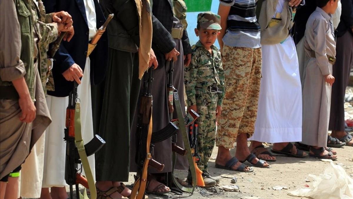 Un niño yemení participa en una marcha junto a varios rebeldes huties para reclutar más efectivos para defender el frente de Hodeida.-YAHYA ARHAB (EFE)