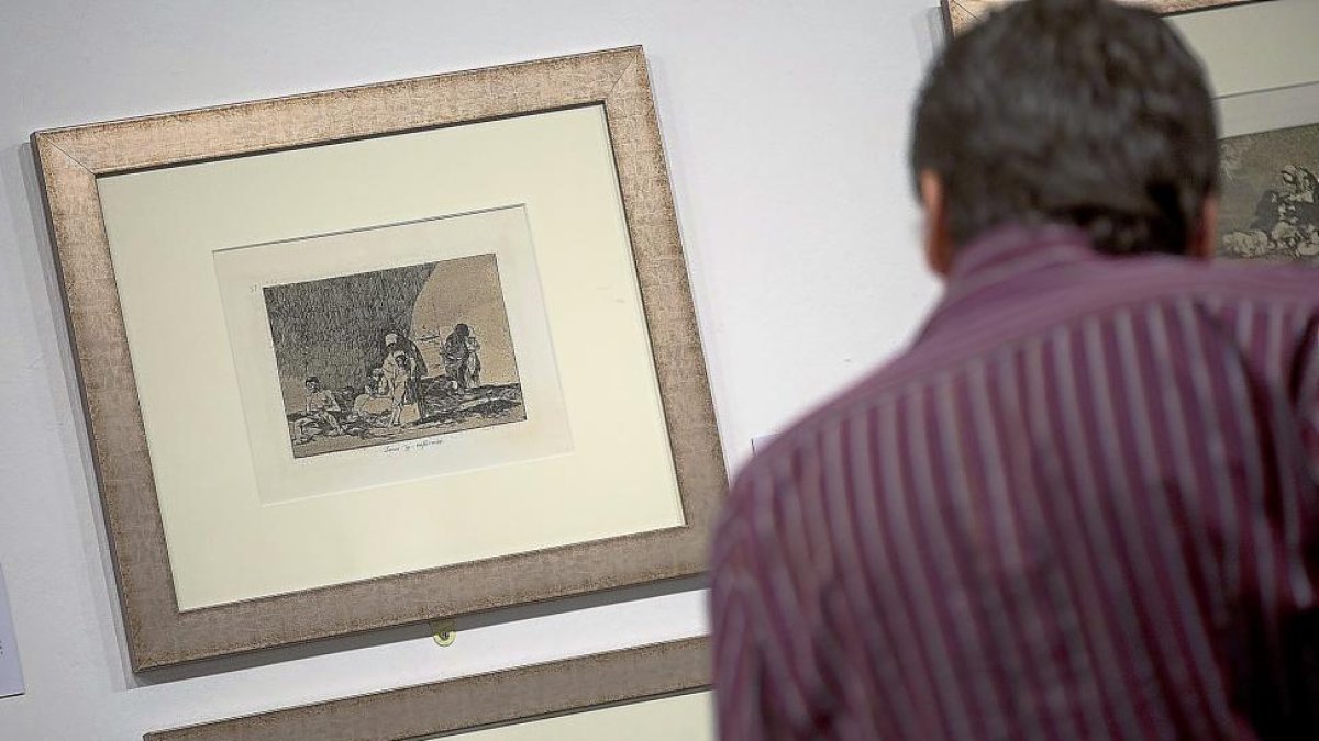 Un hombre contempla algunos de los grabados de la exposición.-TEO SANCHO