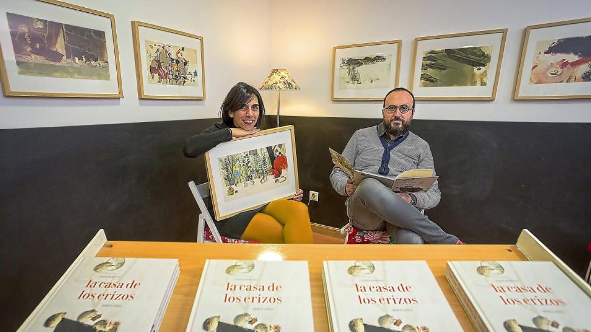 Mercè López y Ángel Domingo, ayer en El Lobo Feroz junto a ilustraciones y varios ejemplares del cuento.-MIGUEL ÁNGEL SANTOS