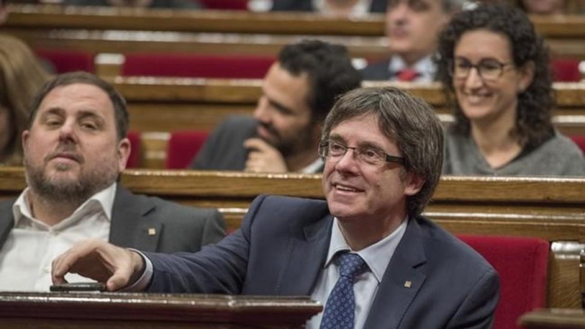 Carles Puigdemont, junto a Oriol Junqueras, en el Parlament.-FERRAN SENDRA