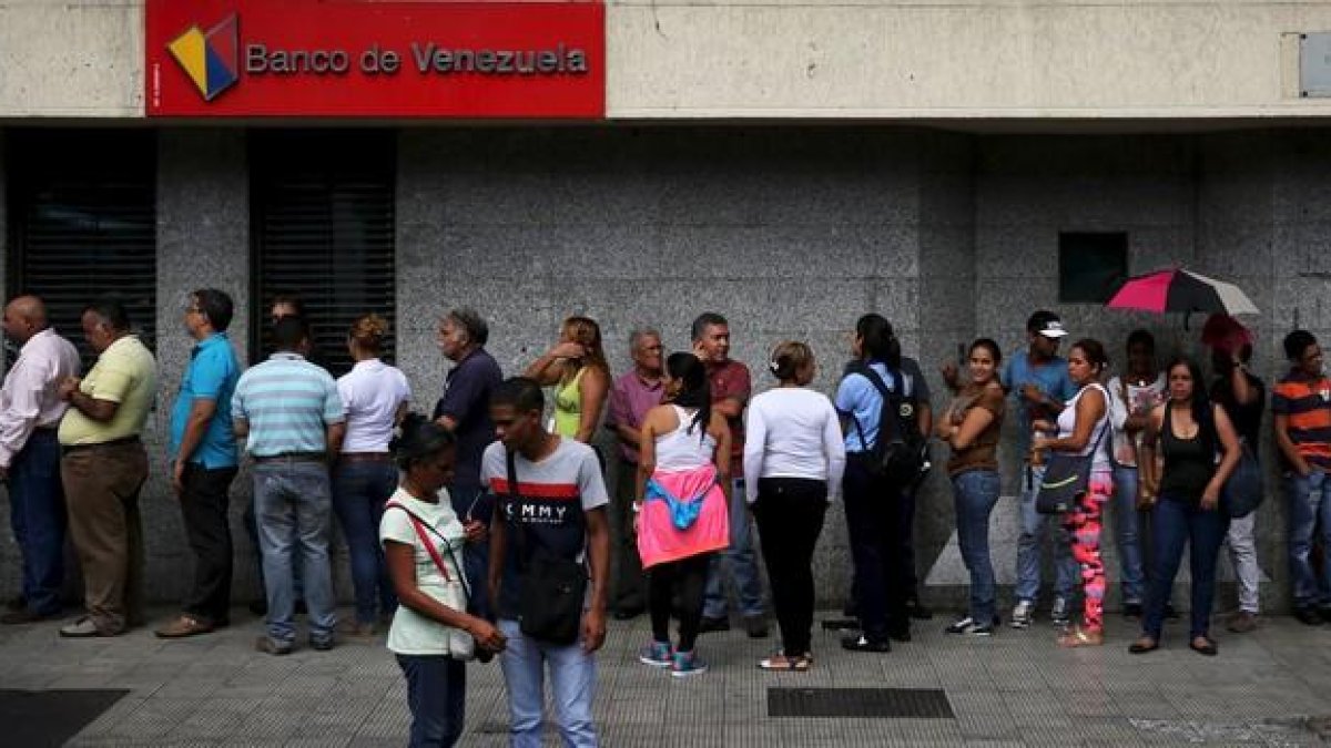 Ciudadanos venezolanos hacen cola en una cajero automático en una sucursal bancaria en Caracas, el viernes.-REUTERS / NACHO DOCE