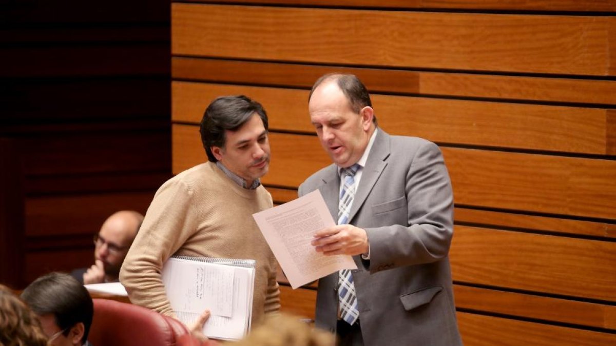 El procurador de Podemos Carlos Eduardo Chávez y el procurador socialista José Luis Aceves, conversan durante el Pleno de las Cortes de Castilla y León-ICAL