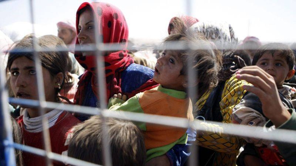 Una familia siria aguarda cerca de la frontera tras huir de su país.-Foto: EFE